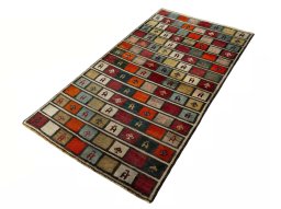 Corner detail of 2000s Persian Gabbeh rug showing border pattern and Wool pile