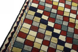 Backside of handmade 2000s Persian Gabbeh rug showing knot structure and weave density