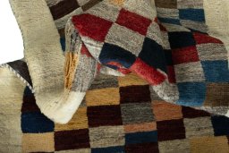 Corner detail of 2000s Persian Gabbeh rug showing border pattern and Wool pile