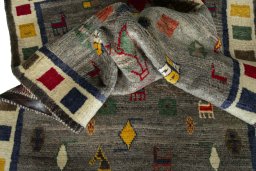 Corner detail of 2000s Persian Gabbeh rug showing border pattern and Wool pile