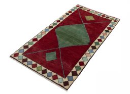 Corner detail of 2000s Persian Gabbeh rug showing border pattern and Wool pile