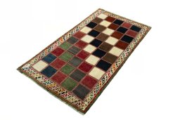 Corner detail of 2000s Persian Gabbeh rug showing border pattern and Wool pile
