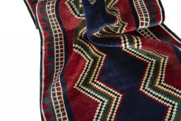Corner detail of 2000s Persian Gabbeh rug showing border pattern and Wool pile