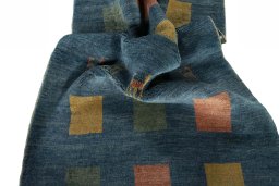 Corner detail of 2000s Persian Gabbeh rug showing border pattern and Wool pile