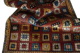 Corner detail of 2000s Persian Gabbeh rug showing border pattern and Wool pile