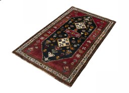 Corner detail of 2000s Persian Gabbeh rug showing border pattern and Wool pile