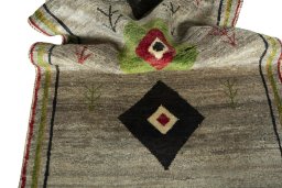 Corner detail of 2000s Persian Gabbeh rug showing border pattern and Wool pile