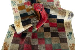 Corner detail of 2000s Persian Gabbeh rug showing border pattern and Wool pile