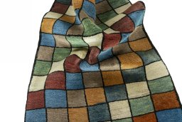 Corner detail of 2000s Persian Gabbeh rug showing border pattern and Wool pile