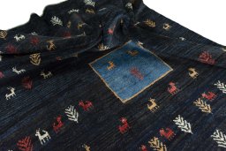 Corner detail of 2000s Persian Gabbeh rug showing border pattern and Wool pile