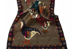 Corner detail of 2000s Persian Gabbeh rug showing border pattern and Wool pile
