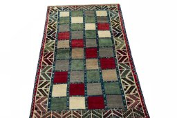 Surface texture of 2000s Persian Gabbeh rug with natural Wool and intricate pattern