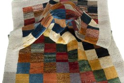Corner detail of 2000s Persian Gabbeh rug showing border pattern and Wool pile