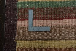 Corner detail of 2000s Persian Gabbeh rug showing border pattern and Wool pile