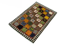 Corner detail of 2000s Persian Gabbeh rug showing border pattern and Wool pile