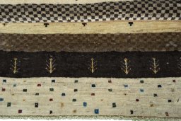 Corner detail of 2000s Persian Gabbeh rug showing border pattern and Wool pile