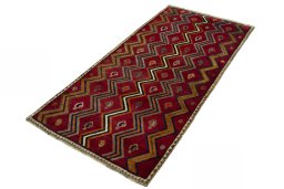 Corner detail of 2000s Persian Gabbeh rug showing border pattern and Wool pile
