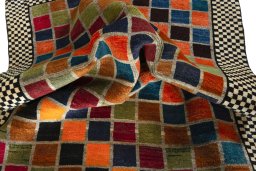 Corner detail of 2000s Persian Gabbeh rug showing border pattern and Wool pile