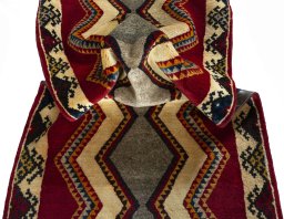 Corner detail of 2000s Persian Gabbeh rug showing border pattern and Wool pile