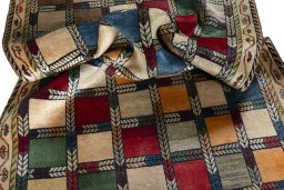 Corner detail of 2000s Persian Gabbeh rug showing border pattern and Wool pile
