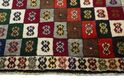 Backside of handmade 2000s Persian Gabbeh rug showing knot structure and weave density