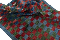 Corner detail of 2000s Persian Gabbeh rug showing border pattern and Wool pile