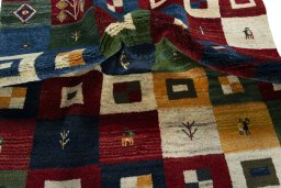 Corner detail of 2000s Persian Gabbeh rug showing border pattern and Wool pile