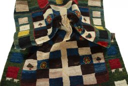 Corner detail of 2000s Persian Gabbeh rug showing border pattern and Wool pile