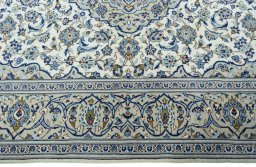 Corner detail of 2000s Kashan rug showing border pattern and Wool pile