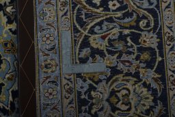 Backside of handmade New Kashan rug showing knot structure and weave density