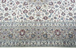 Corner detail of 2000s Kashan rug showing border pattern and Wool pile