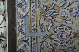 Backside of handmade 2000s Kashan rug showing knot structure and weave density