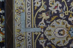 Backside of handmade 2000s Kashan rug showing knot structure and weave density