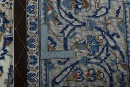 Backside of handmade 2000s Kashan rug showing knot structure and weave density