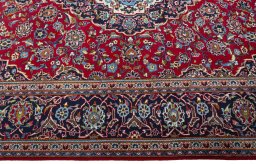 Corner detail of 2000s Kashan rug showing border pattern and Wool pile
