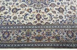 Corner detail of 2000s Kashan rug showing border pattern and Wool pile