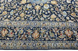 Corner detail of 2000s Kashan rug showing border pattern and Wool pile