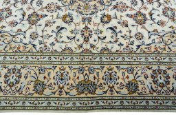 Corner detail of 2000s Kashan rug showing border pattern and Wool pile