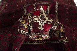 Corner detail of 2000s Baloch rug showing border pattern and Wool pile