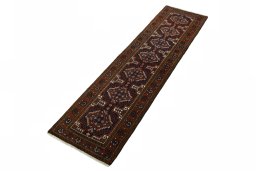 Corner detail of 2000s Baloch rug showing border pattern and Wool pile