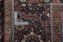 Backside of handmade 1930s Heriz rug showing knot structure and weave density
