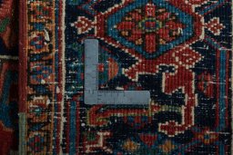 Backside of handmade 1930s Heriz rug showing knot structure and weave density