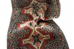 Corner detail of 2000s Senneh rug showing border pattern and Wool pile