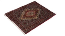 Corner detail of 1990s Senneh rug showing border pattern and Wool pile