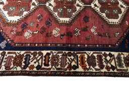 Corner detail of 2000s Shiraz rug showing border pattern and Wool pile