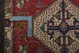 Backside of handmade 2000s Shiraz rug showing knot structure and weave density