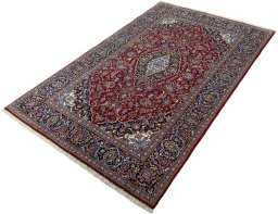 Corner detail of 2000s Kashan rug showing border pattern and Cork pile