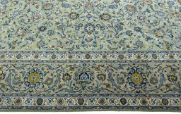 Corner detail of 2000s Kashan rug showing border pattern and Wool pile