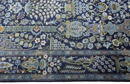 Corner detail of 2000s Kashan rug showing border pattern and Wool pile