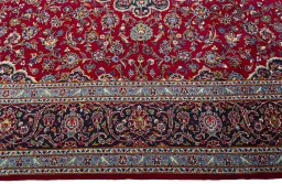 Corner detail of 2000s Kashan rug showing border pattern and Wool pile